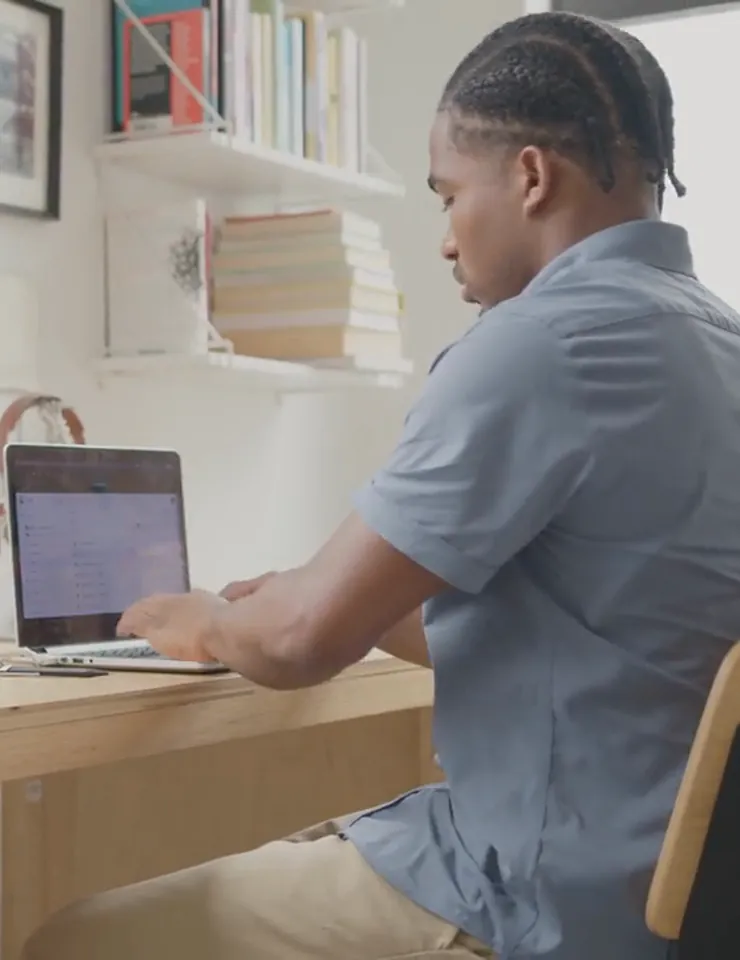 Adult working at a desk with a laptop
